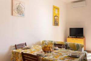 uma mesa de jantar e um sofá com mesa e copos em Villa vista mare ~Villa Dafne~ em Noto Marina