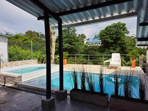 a swimming pool with a pergola next to a house at Casa de Campo Las Partidas in Quimbaya
