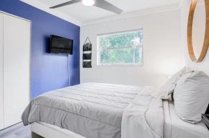 a bedroom with a bed with a blue wall at 4br 3ba Spacious Home 2 Master Suites Near Usf in Tampa
