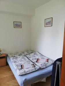 a bed in a room with two pictures on the wall at Útulný 3-izbový byt v srdci Tatier in Vysoké Tatry