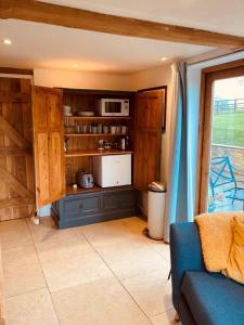sala de estar con sofá y cocina en 2 Beds & living in our idyllic country Cottage, en Bedford