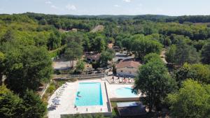 una vista aérea de una gran piscina con árboles en Gîte dans camping 4 étoiles, en Tourtoirac