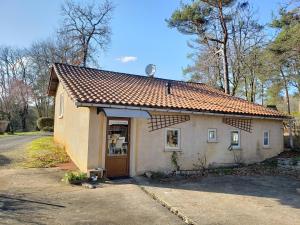 un pequeño edificio blanco con techo marrón en Gîte dans camping 4 étoiles, en Tourtoirac