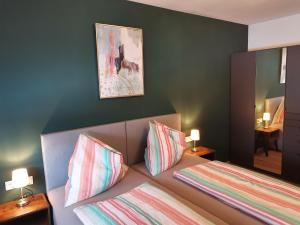una camera da letto con un letto con due cuscini e uno specchio di Berg:Zeit_Apartments a Tamsweg