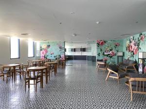 uma sala de jantar com mesas e cadeiras e flores nas paredes em Sea view Arena apartment near Cam Ranh airport em Cam Ranh
