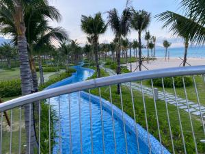 uma vista a partir da varanda de um resort com uma piscina e palmeiras em Sea view Arena apartment near Cam Ranh airport em Cam Ranh
