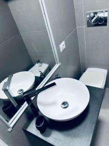 a bathroom with two white sinks and a toilet at Piazza Verdi Apartment in Bologna