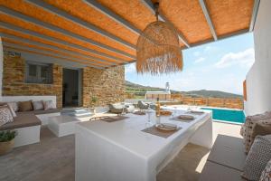un soggiorno con tavolo bianco e ampia finestra di Xerolithia suites a Agios Sostis