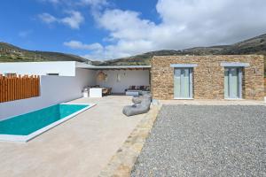 a backyard with a swimming pool and a house at Xerolithia suites in Agios Sostis