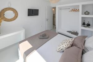 un soggiorno bianco con divano e specchio di Xerolithia suites a Agios Sostis