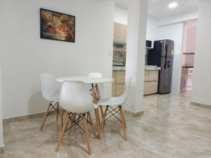 kuchnia z białym stołem i 2 białymi krzesłami w obiekcie El mejor en Cali Espectacular apto 3A zona sur w mieście Cali