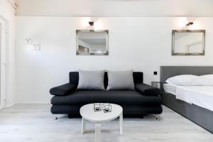 uma sala de estar com um sofá preto e uma mesa branca em Apartment Lusy Lo em Zadar