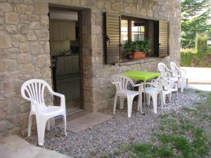 eine Gruppe weißer Stühle und ein Tisch auf einer Terrasse in der Unterkunft AlpensHolidays Les Pallissses in Alpens