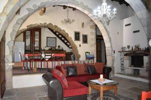 a living room with a red couch and a fireplace at Traditional Villa with pool in Sfakia in Ímbros