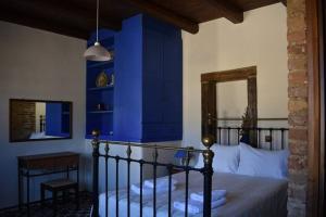 een slaapkamer met blauwe muren en een bed en een tafel bij Traditional Villa with pool in Sfakia in Ímbros