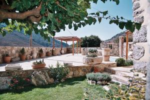 a garden with a stone walkway with a pergola at Traditional Villa with pool in Sfakia in Ímbros