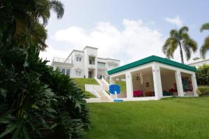 a large white house with a green roof at Campestre para familias grupos en Puerto Rico in Luquillo