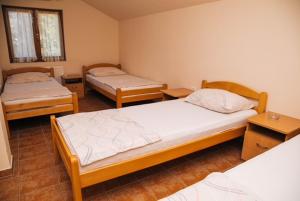a room with two beds and two tables at Jezero Laminci in Bosanska Gradiška
