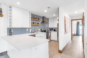 una cucina con armadi bianchi e piano di lavoro bianco di Pirate Beach Hideaway | Flagler Beach a Flagler Beach