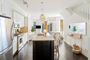 a kitchen with white cabinets and a kitchen island at The Beach House at Barona Beach 4301 in West Kelowna