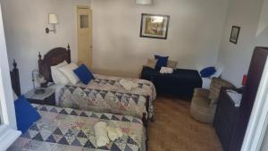 mały pokój z 2 łóżkami i kanapą w obiekcie Casa da Praia do Ribatejo - Casa da Arcada w mieście Praia do Ribatejo