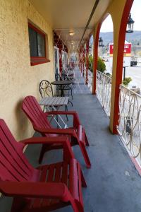 un patio con sillas rojas y mesas en un balcón en Spanish Villa Resort, en Penticton