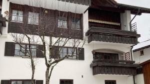 un bâtiment avec des balcons et un arbre en face de celui-ci dans l'établissement FeWo Sonnenschein, Oberstaufen, à Oberstaufen
