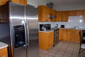 uma cozinha com um frigorífico de aço inoxidável e armários de madeira em Spanish Villa Resort em Penticton