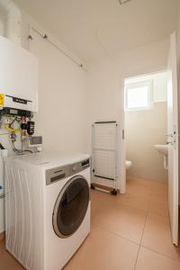 a white washer and dryer in a bathroom at ROZÉ BLUE DESIGN APARTMENTS in Csopak