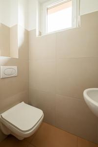 a bathroom with a toilet and a sink at ROZÉ BLUE DESIGN APARTMENTS in Csopak