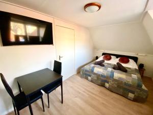 The island life Texel في دن بورخ: غرفة نوم صغيرة مع سرير وطاولة