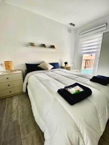 a white bed with a black tray on top of it at Ferrer in El Campello