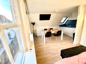 The island life Texel في دن بورخ: غرفة مع طاولة وكراسي ومطبخ