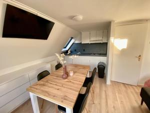 登堡的住宿－The island life Texel，厨房以及带木桌的用餐室。