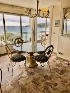 a dining room with a glass table and chairs at Magnifique T4 face à la mer, vue panoramique 180° in Roquebrune-Cap-Martin