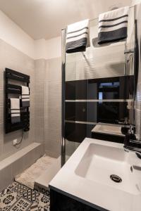 La salle de bains est pourvue d'un lavabo, d'une douche et de serviettes. dans l'établissement Le 23 Centre-ville (classé 3 ***), à Clermont-Ferrand