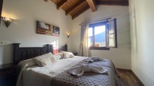 Apartamentos Rurales Quintana de LLanes في يانس: غرفة نوم بسرير عليها روب