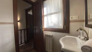 baño con lavabo, ventana y espejo en Apartamentos Rurales Quintana de LLanes, en Llanes