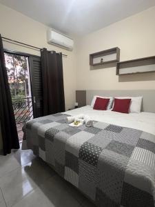 1 dormitorio con 1 cama grande y balcón en Apartamento Aconchegante, en Brotas