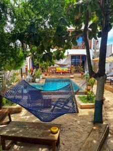 a blue hammock hanging from a tree next to a pool at Utulivu Bungalow in Nungwi