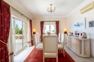 Un comedor con una mesa de cristal y sillas. en Villa White Cottage by SAPvillas, en Vilamoura