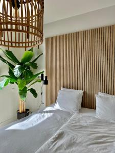 a bedroom with a bed and a potted plant at Oranje Nassau aan Zee Appartement in Zandvoort