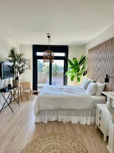 a bedroom with a large white bed and a window at Oranje Nassau aan Zee Appartement in Zandvoort