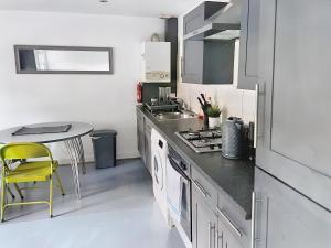 Lovely 2-bedroom serviced apartment Greater London في لندن: مطبخ مع مغسلة وطاولة فيه