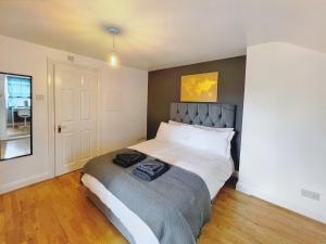 Lovely 2-bedroom serviced apartment Greater London في لندن: غرفة نوم بسرير كبير في غرفة