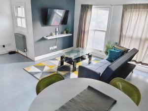 uma sala de estar com uma mesa e um sofá em Lovely 2-bedroom serviced apartment Greater London em Londres