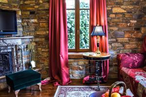 a living room with red curtains and a fireplace at Archontiko Polyzos in Portaria