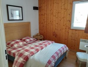sypialnia z łóżkiem z czerwonym i białym kocem w obiekcie Appartement Val de Roland w mieście Luz-Saint-Sauveur