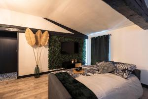 - une chambre dotée d'un lit avec un mur vert dans l'établissement Le 23 Centre-ville (classé 3 ***), à Clermont-Ferrand
