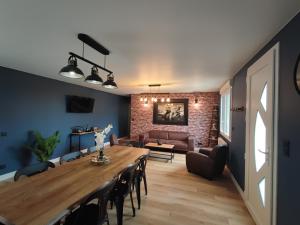 a living room with a table and a couch at Le Gîte de Daisy in Saint-Côme-du-Mont
